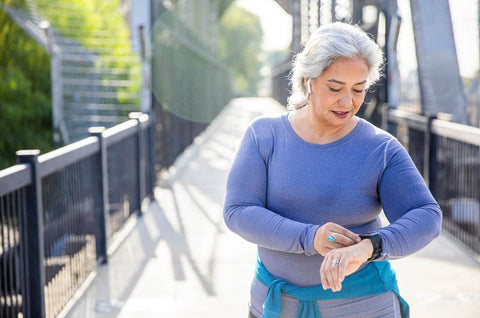 A woman looks at the Fitness Tracker on her wrist