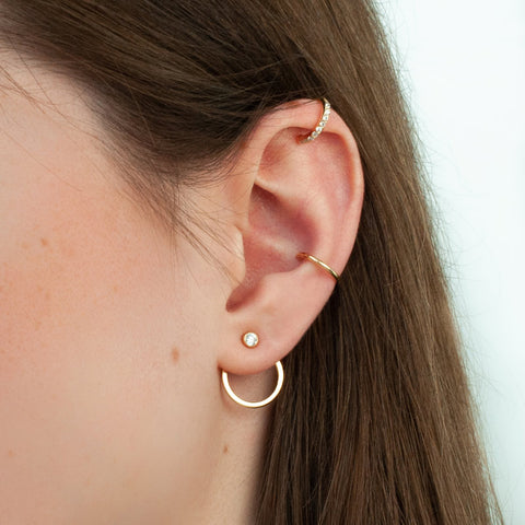 A woman wears ear CZ jacket with stud earring, cuff earring and cartilage cuff earring with CZ