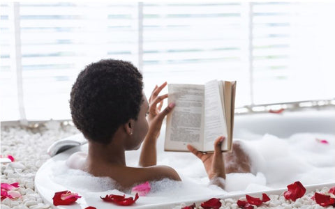 Relaxing scene of a woman immersed in a book while enjoying a bath, creating a tranquil and leisurely atmosphere.