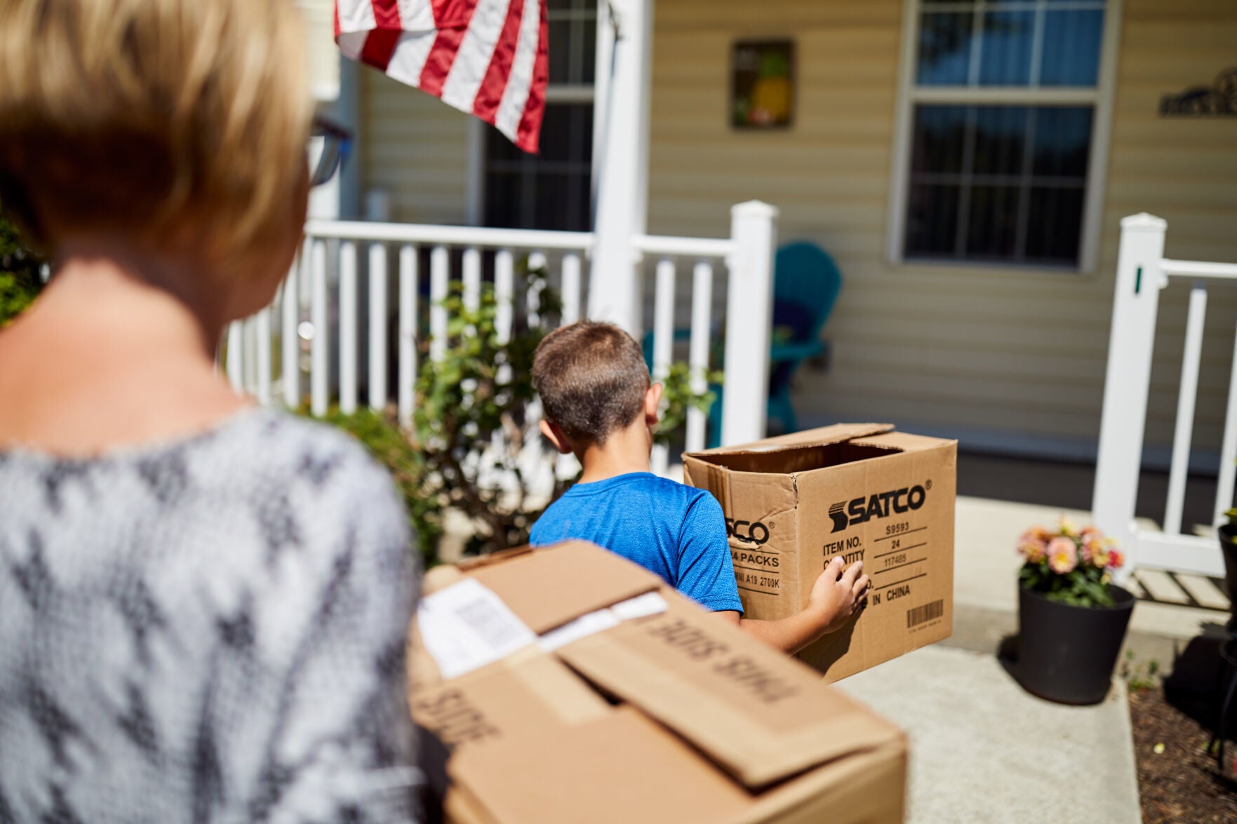 Members of a family carry boxes during a PCS military move.