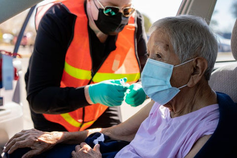 Doctor giving shot to elderly woman