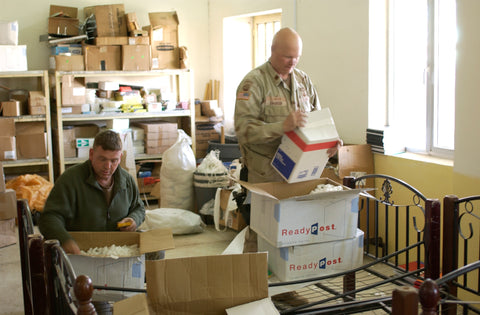 two men in storeroom sorting boxes