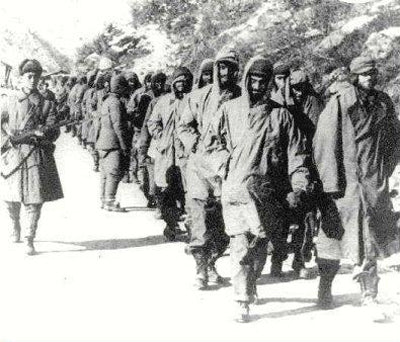 Americans captured in the Korean war being marched with guard at the side