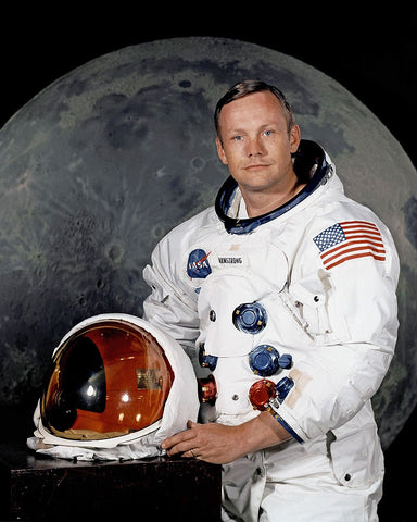 USN pilot Buzz Armstrong in space suit with helmet off and flag in background