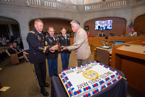 US Army officers in uniforms cutting large cake