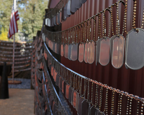 dog tags hanging from memorial wall