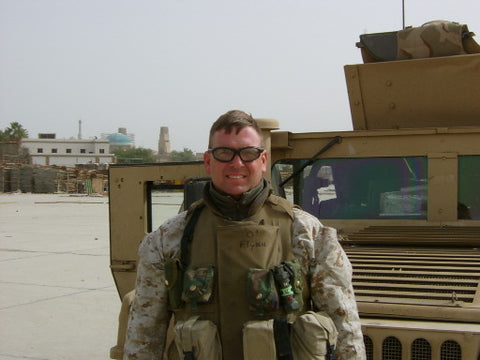 David A. Flynn in army fatigues in front of Humvee