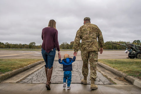 Soldier with wife and child holding hands