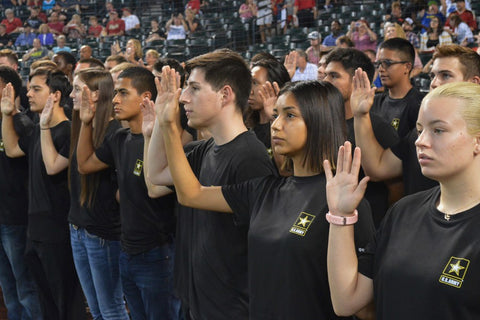 Recruits in a stadium being sworn into the US Army