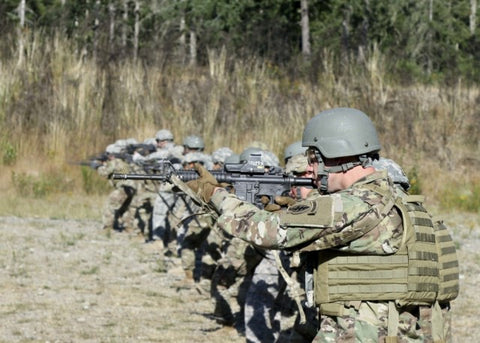 US Army special forces soldiers standing in line firing m-4 rifles