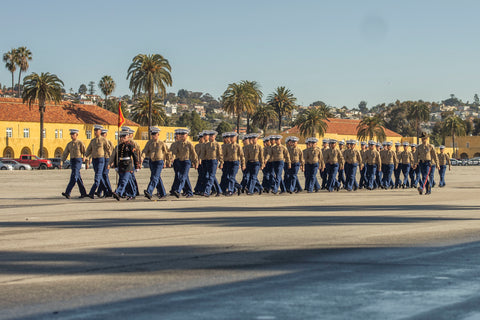 Marines marching in formation with dress uniforms