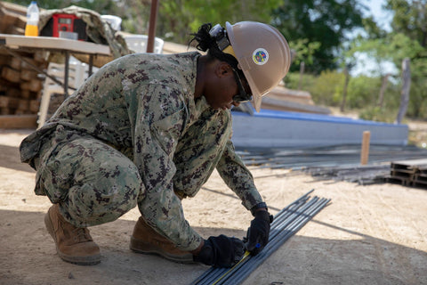 soldier measuring rebar on construction site