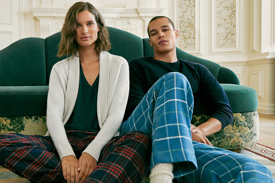 Man and woman sat on ground in pyjamas and cashmere