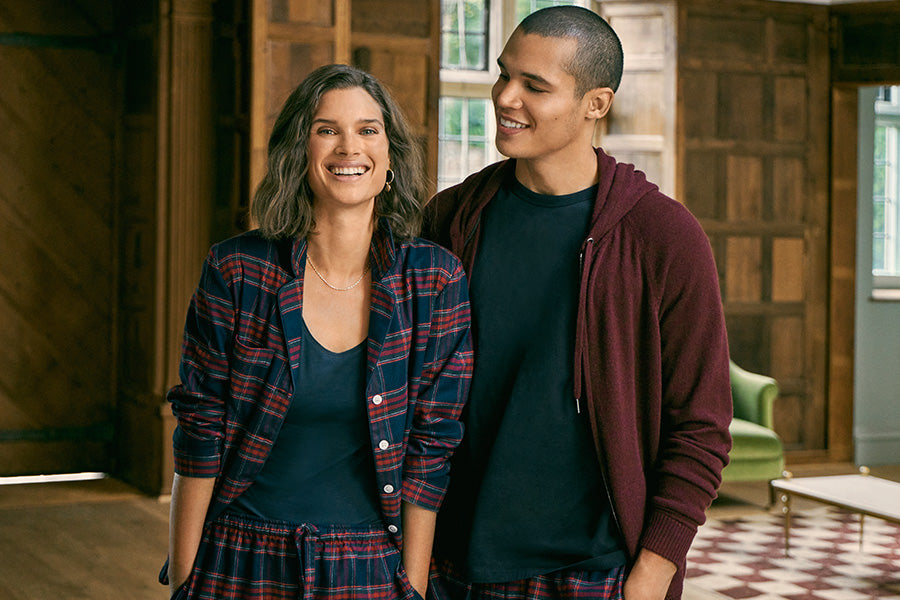 Woman and man laughing in matching pyjamas.