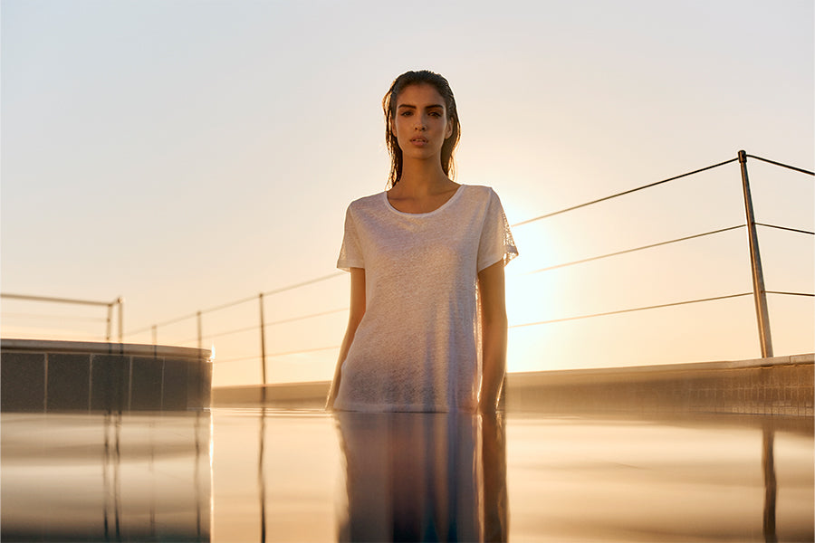 Woman in a pool with a white linen t-shirt on