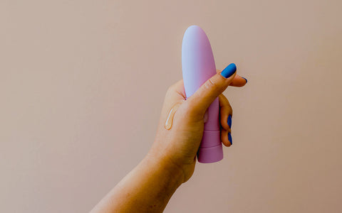 a hand holding a vibrator with dripping lube