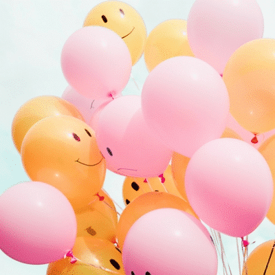 pink and orange balloons with smiles on