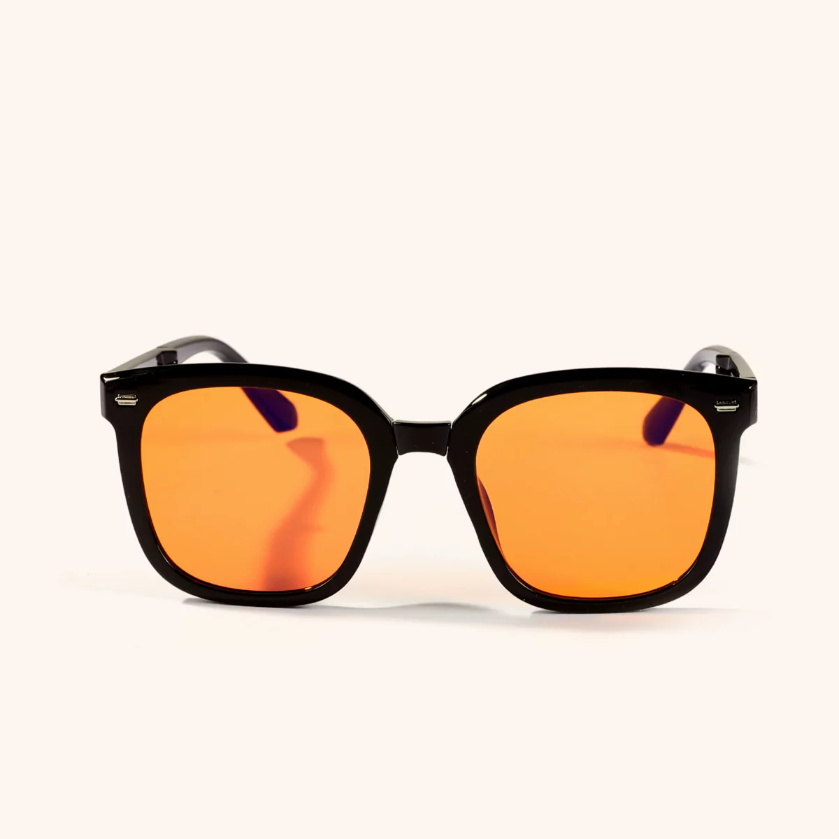 Black-framed sunglasses with orange lenses on a white background.