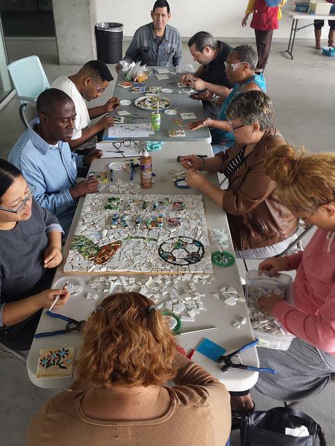 Community member working on Broadway's Blooming mosaic wall.