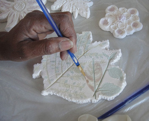 Artist painting a ceramic at a Piece by Piece Workshop