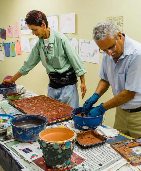 Two Piece by Piece artists working on their mosaic pieces.