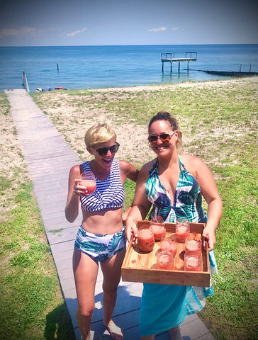 Sarah Nicholas and Fayeruz Regan drinking cocktails on the beach