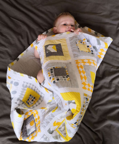 Baby cuddling in a gender neutral baby quilt