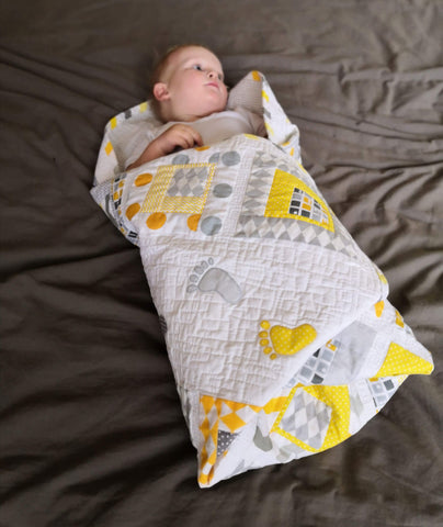 Baby wrapped in a baby quilt "Small Steps"