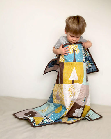A boy playing with "Our forest Winter" quilt