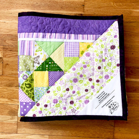 Quilt label on a folded purple quilt