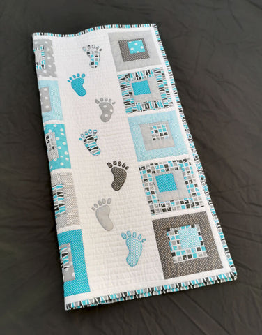 A trail of baby footsteps on a Small Steps quilt