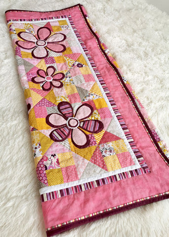 Flower appliques on a pink girl's quilt