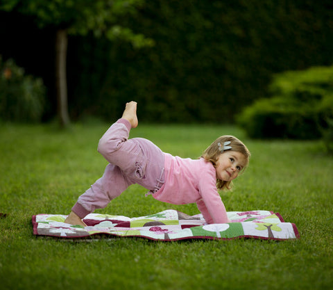 A girl doing yoga on a quilt