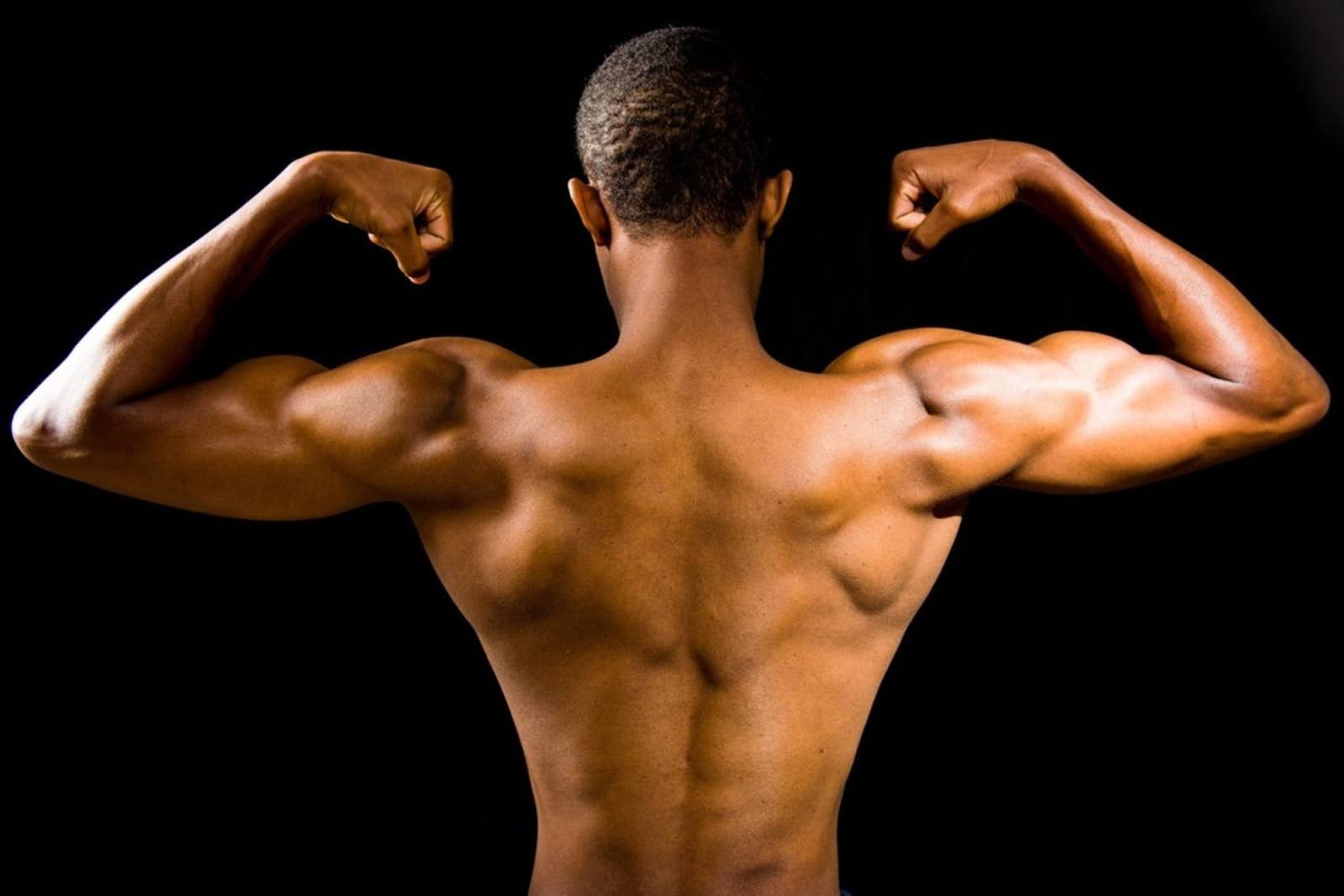 A man flexing showing well-defined muscles on his back and arms.