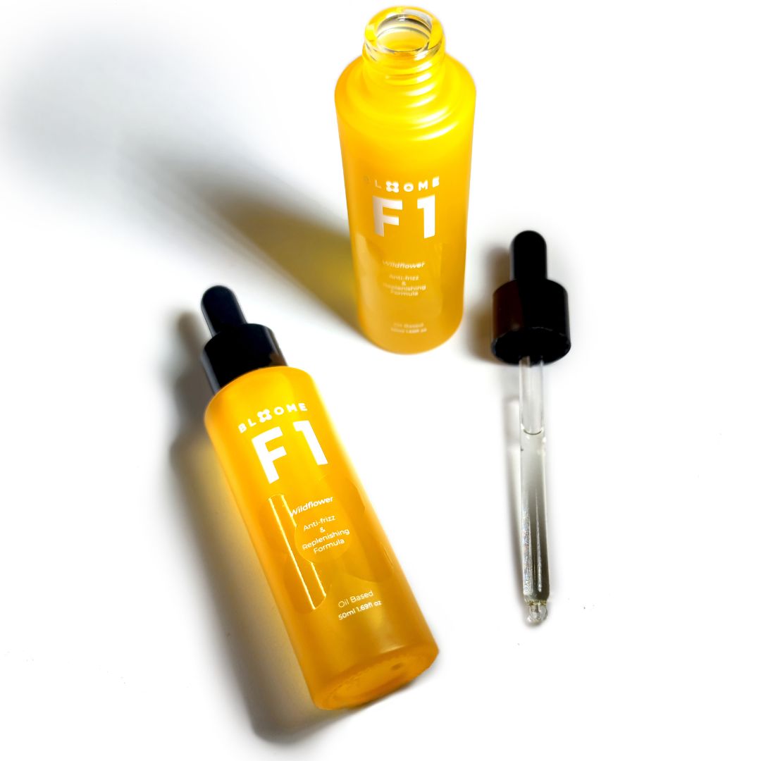 Two yellow bottles of hair serum with a dropper. The serums are called F1 and feature a logo.