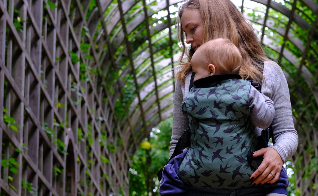 Mother wearing Integra Baby Carrier with her infant in a front carry