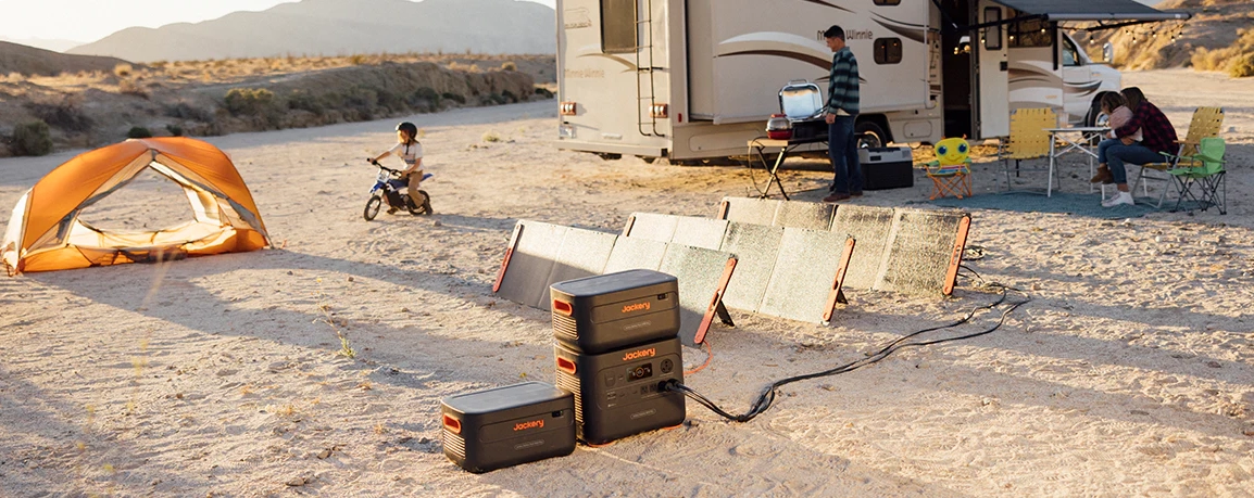 Jackery 2000 Plus Portable Power Station and Two Battery Packs Powering an RV With Solar Panels