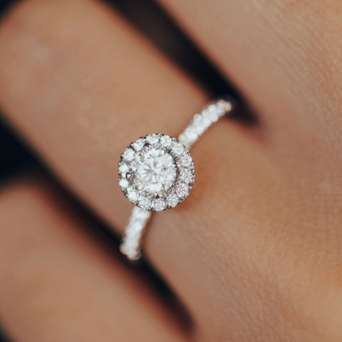 Photo porté d'une bague de fiançailles en diamants avec anneau pavé de pierres.