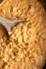 Crock Pot Mac and Cheese in a bowl and wooden spoon