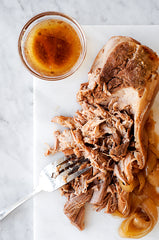 Slow Cooker Pork on a cutting board with gravy