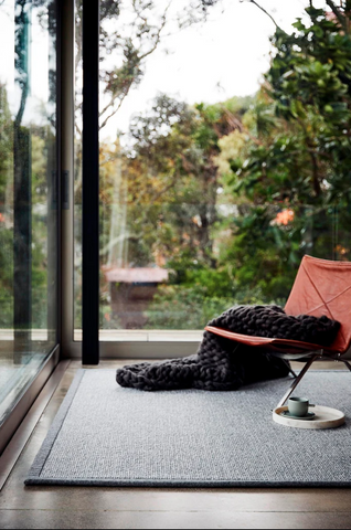 Wool rug with orange chair outlooking green scenery