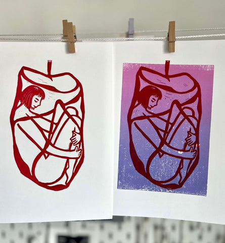 a couple of art prints from lino press on a rope