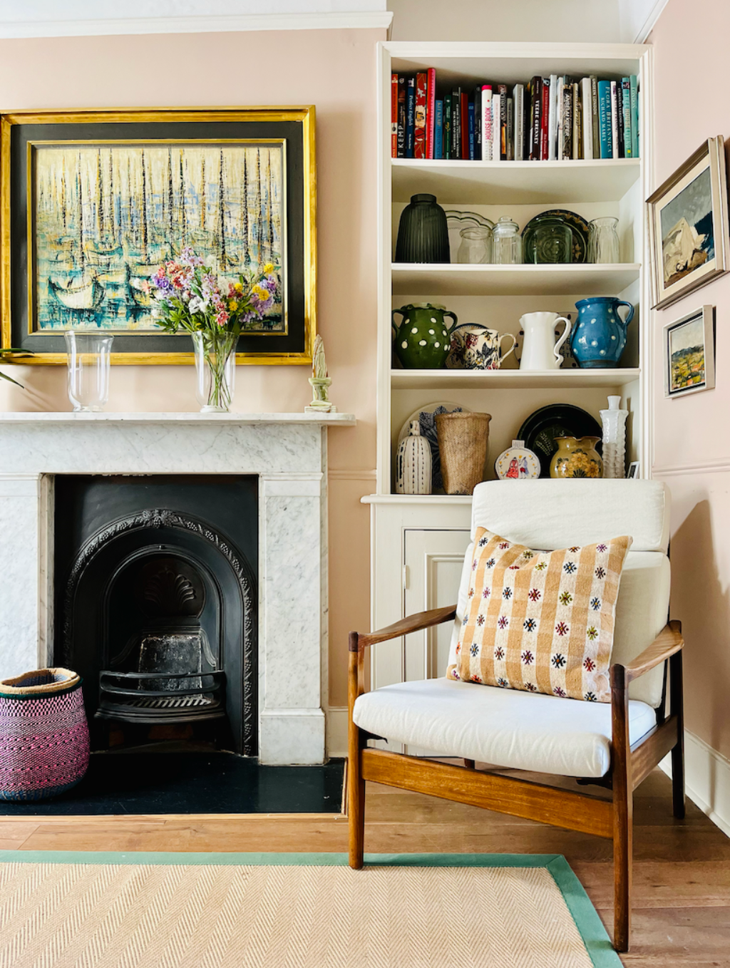 An informal reception area with a collection of antique oil paintings are displayed alongside plates, jugs and vases.