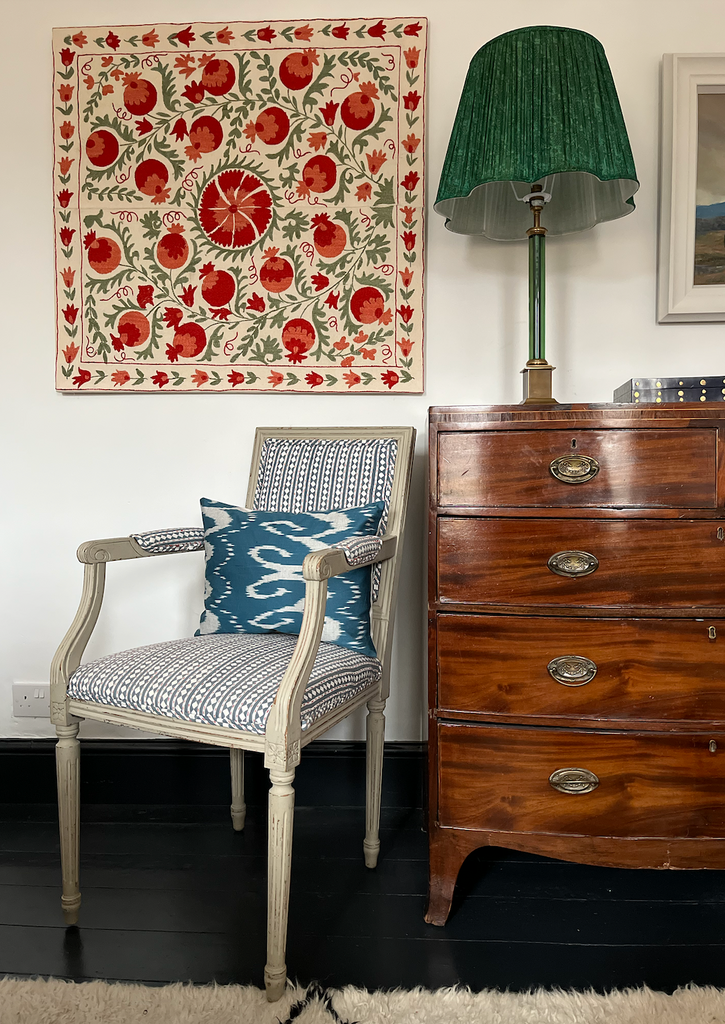 an example of a modern suzani sourced by Holly from India and displayed stretched over a mount alongside her sari scalloped lampshades available on her website.