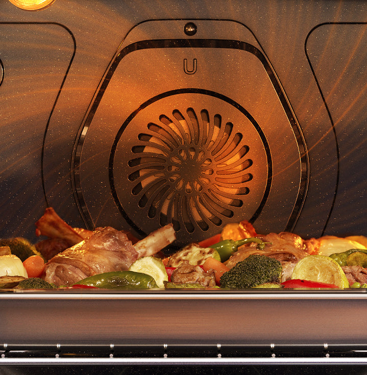 Shows the fan at the back of the oven circulating heated air all around the oven, so that it surrounds a tray of food.