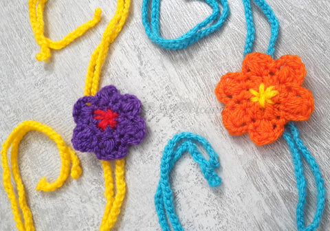 Crochet Flowers in Purple and Orange with braided strands in turquoise and yellow