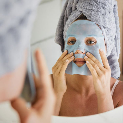 woman using a hyaluronic acid sheet mask on her face