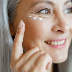 woman applying cream under her eyes