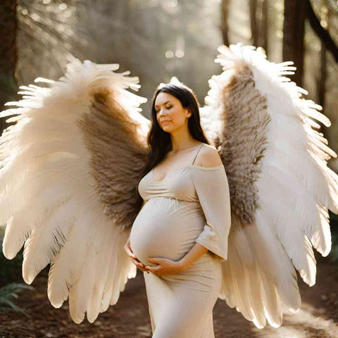 pregnant woman maternity photoshoot with angel wings from feathers in the forest
