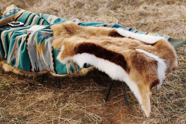A chair covered by a high-end Faux Impala Pelt Rug, and an Aztec Faux Fur Blanket in the background.
